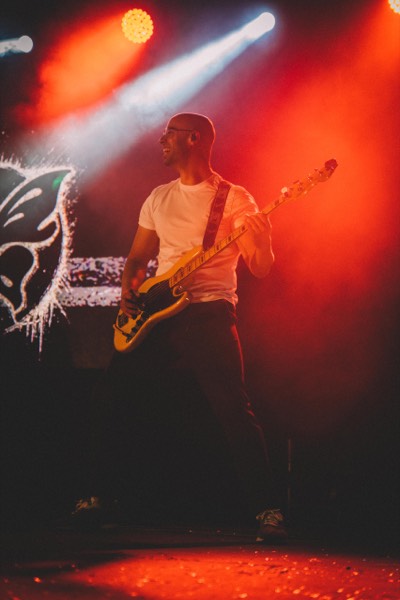 AJ Ruíz al bajo con luces rojas en escenario